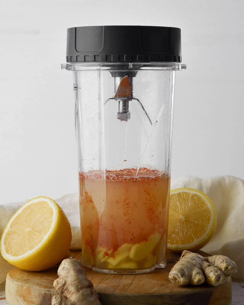 cayenne pepper, lemon juice and ginger in the blender ready to make ginger lemon cayenne shots