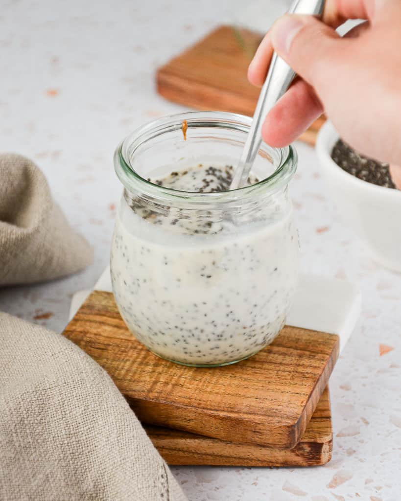 stirring a container of chia pudding