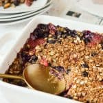 gold spoon scooping out baked oatmeal with berries
