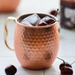 cherry moscow mule in a copper mug with cherries on top