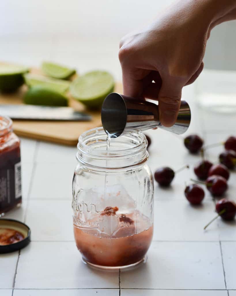 pouring vodka into a mason jar