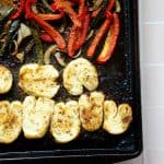 close up of roasted halloumi on a sheet pan with roasted peppers and onions