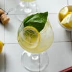 an overhead view of a limoncello spritz with lemons and a muddler underneath
