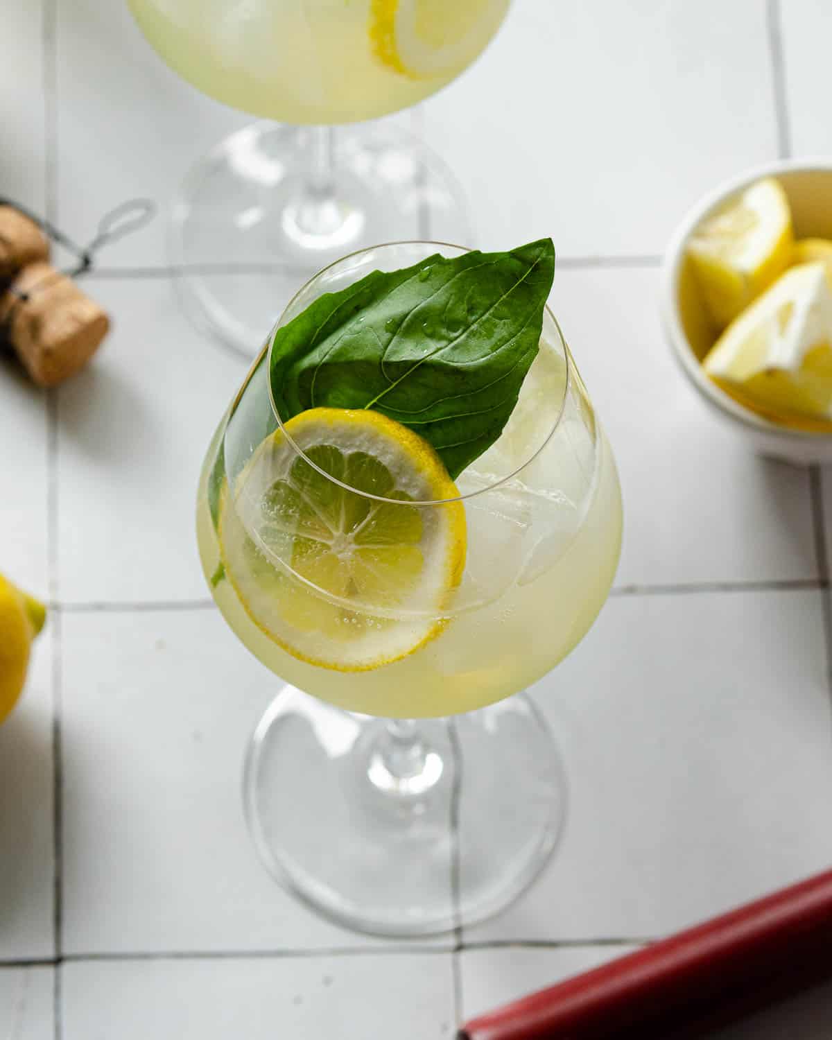 an overhead view of a limoncello spritz with lemons and a muddler underneath
