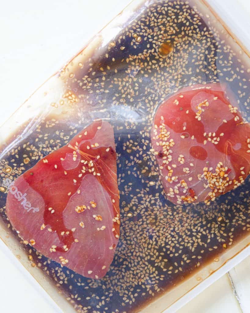 marinating two ahi tuna steaks in a reusable ziplock bag with ponzu sauce inside