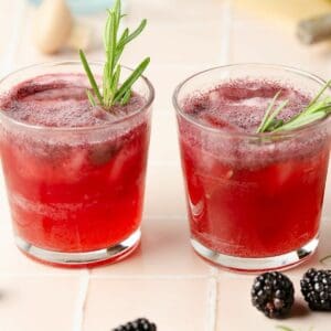 featured square image of two blackberry rosemary margaritas topped with rosemary sprigs and sparkling on top from the ginger beer