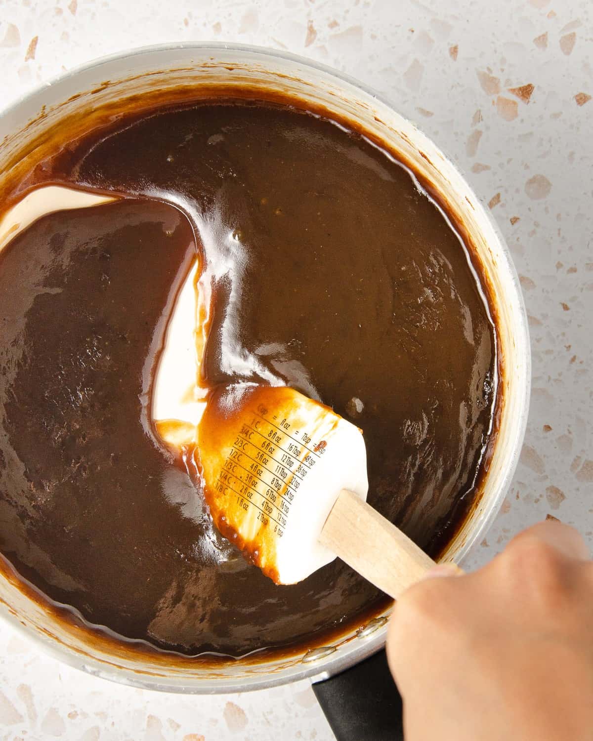 The final step of making vegan salted caramel - add vanilla extract after taking it off the heat and smooth it together.