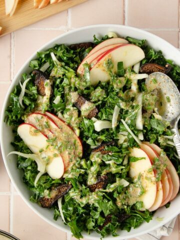 Featured image of a kale fennel apple salad in a large white bowl with lemon dressing.