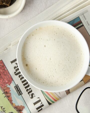 A close up of a London Fog Tea Latte on top of a newspaper.