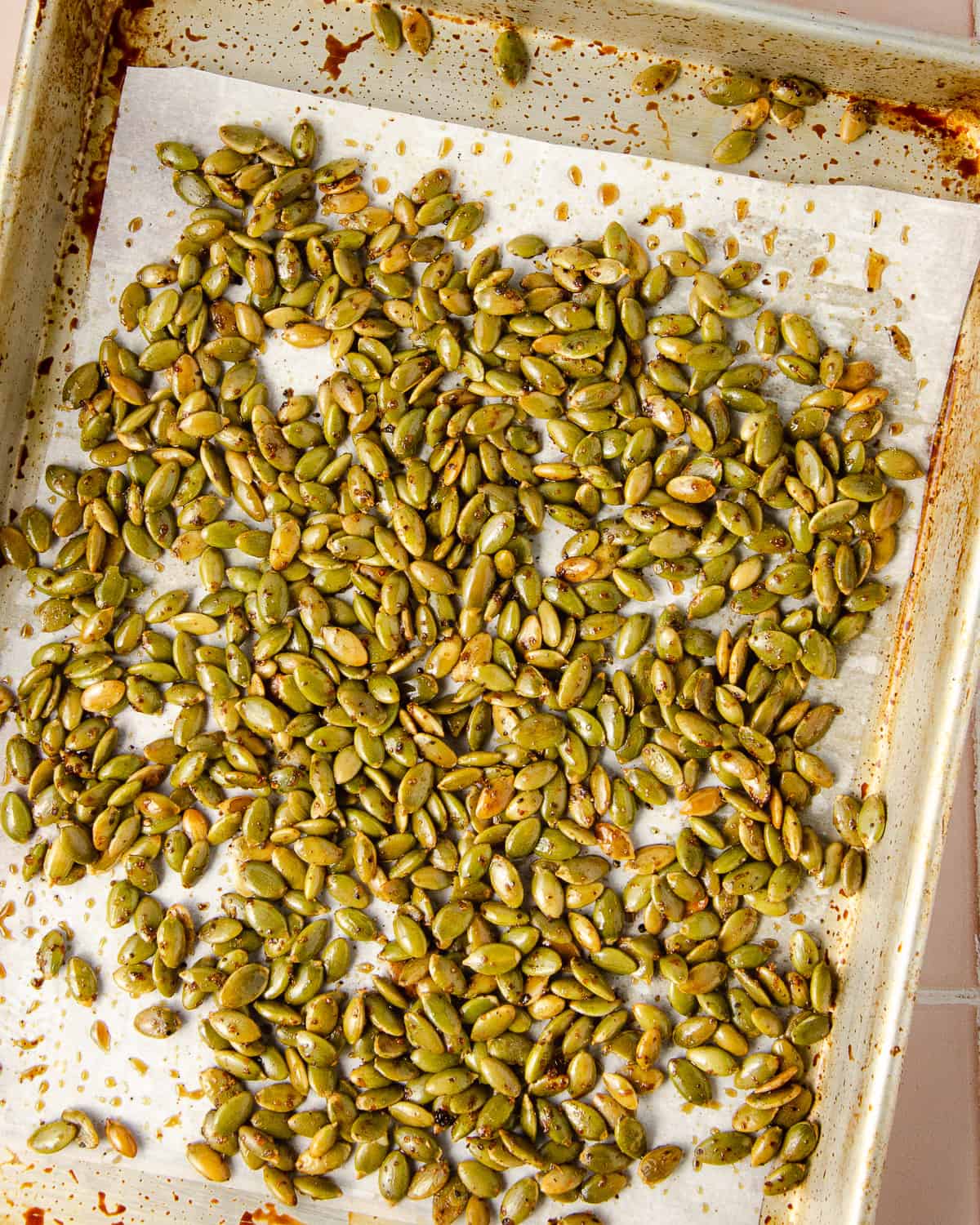 Roasted pepitas on a baking sheet lined with parchment paper.