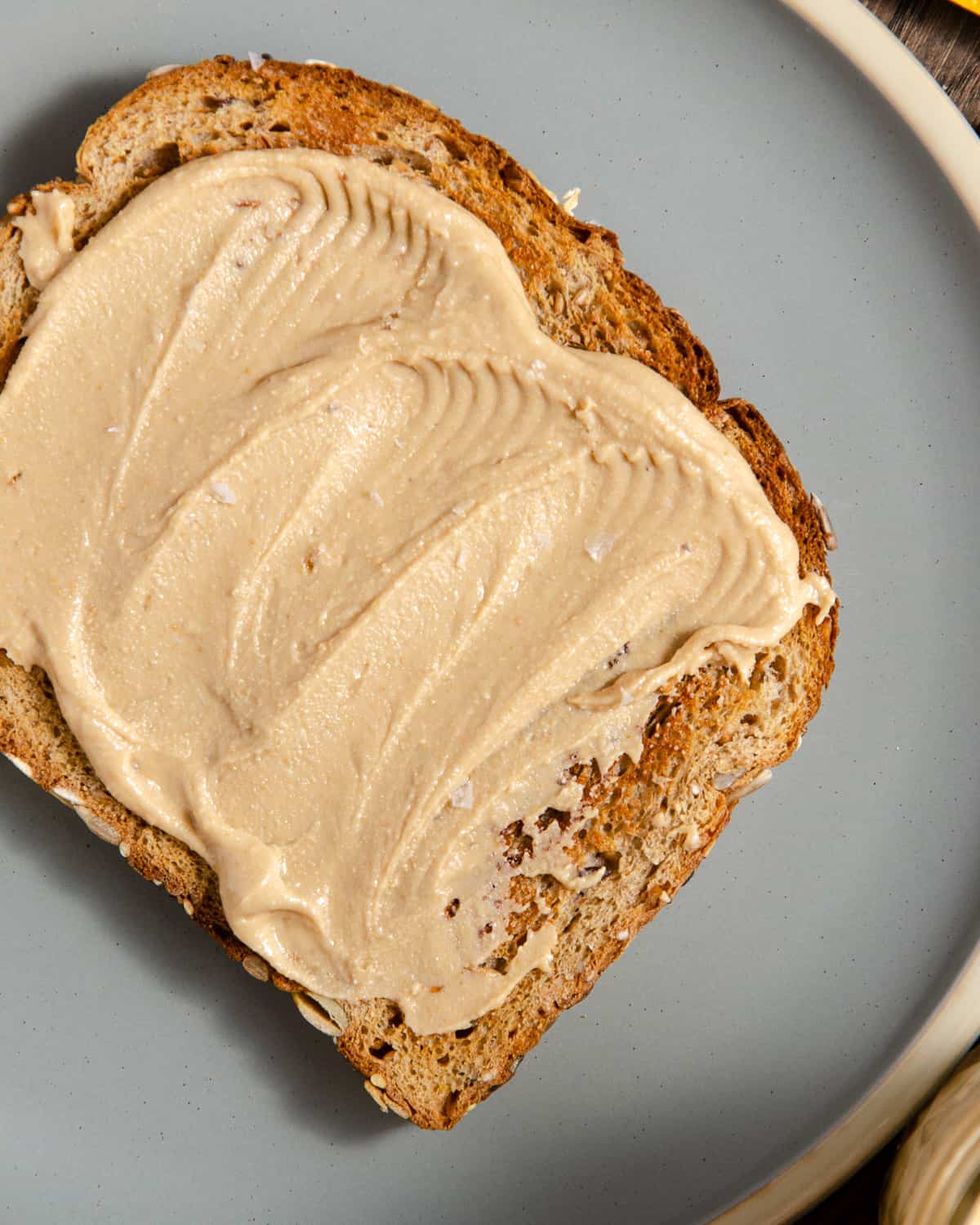 A close up of cashew butter spread on a piece of toast.
