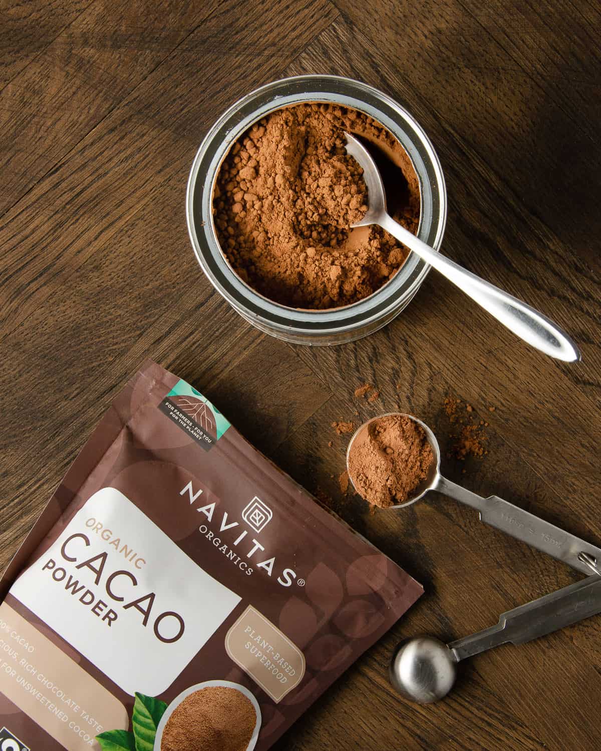 Cocoa powder and cacao powder on a wooden table.