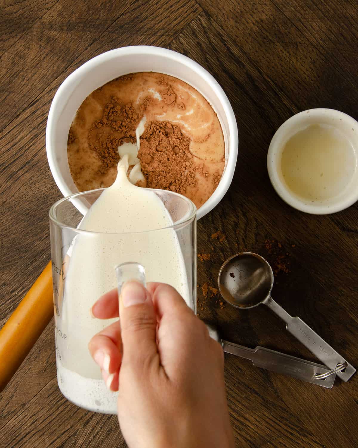 Pouring oat milk into a white pot.