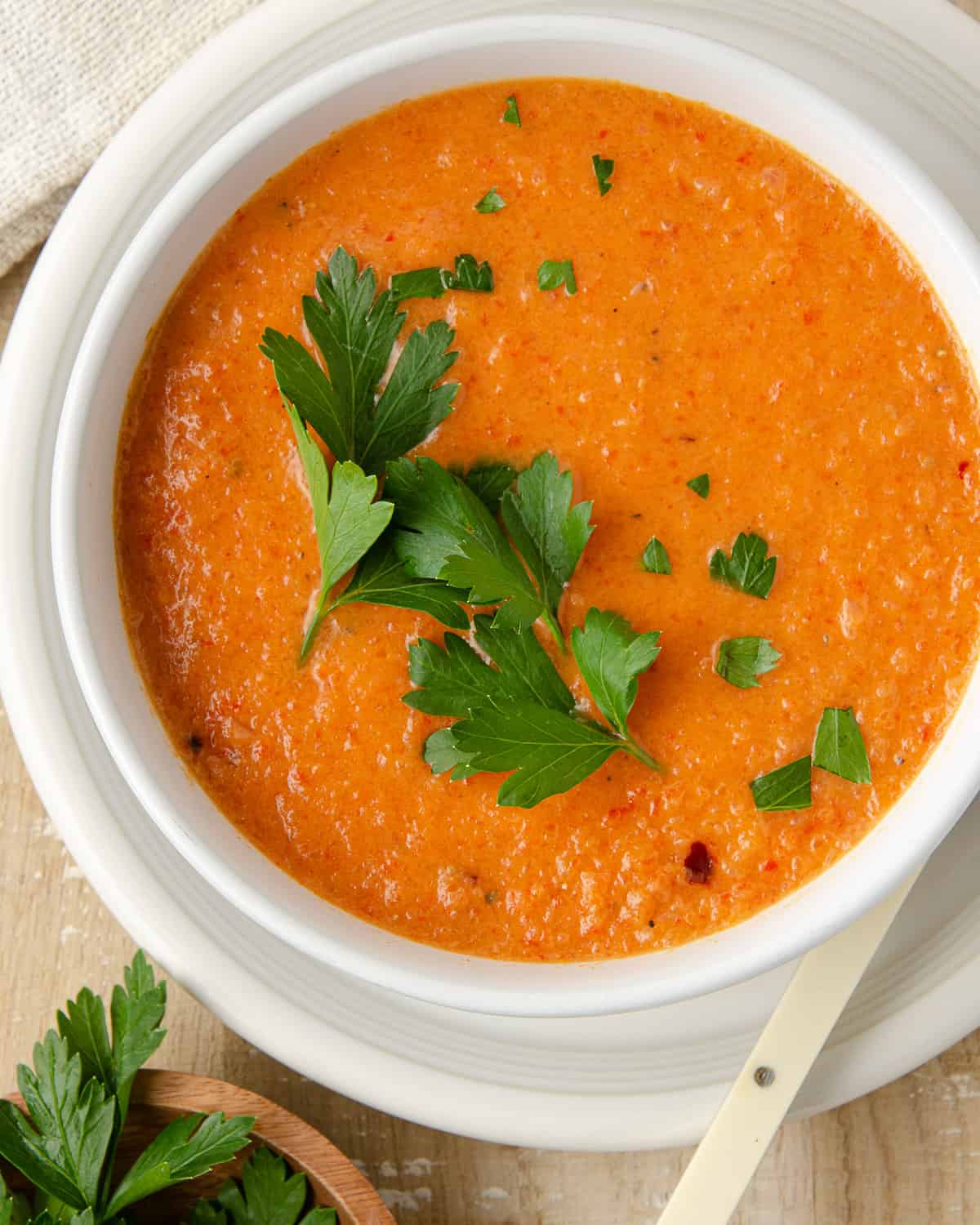 A close up of a bowl of roasted red pepper soup.