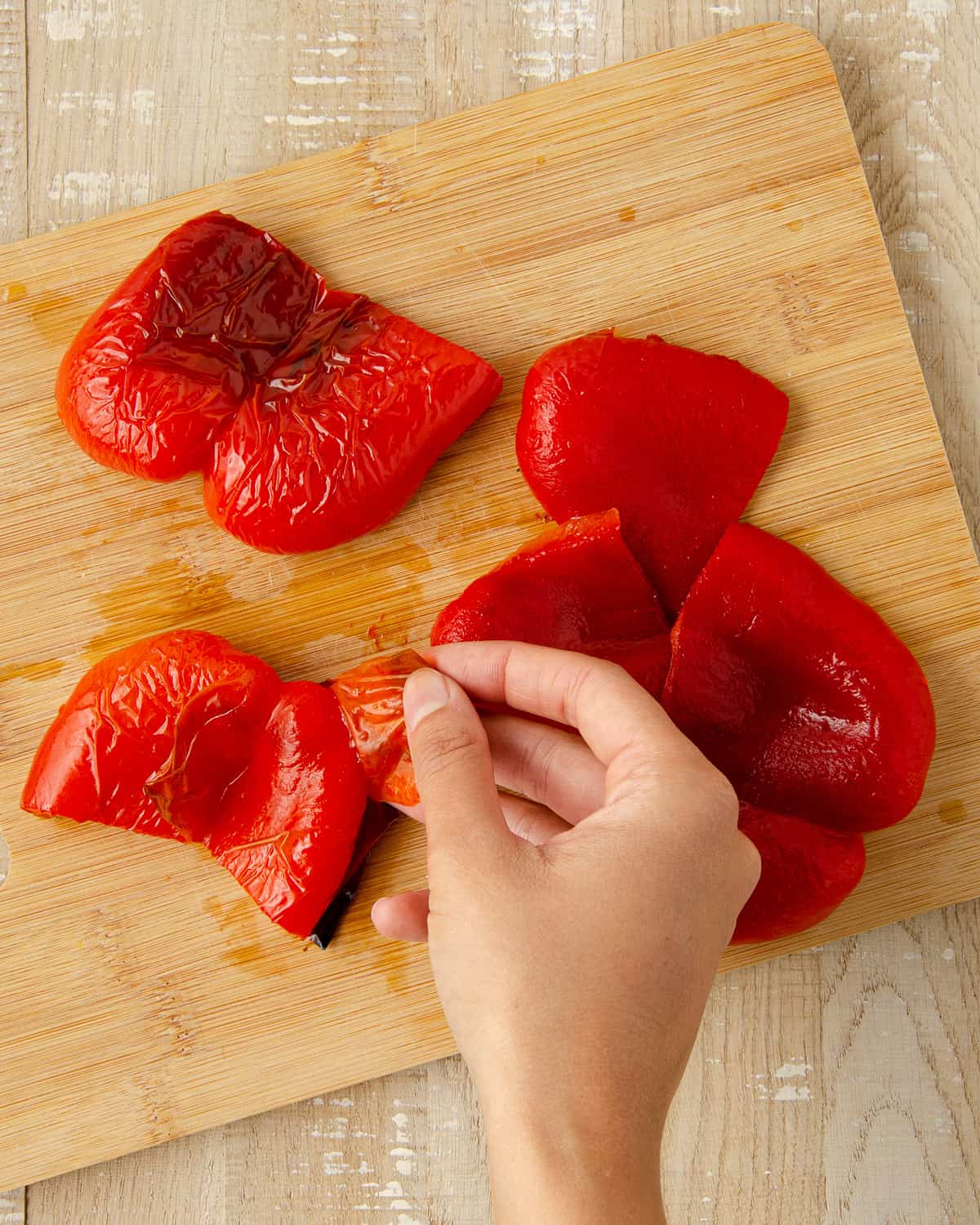 Peeling the skins off of a red bell pepper.