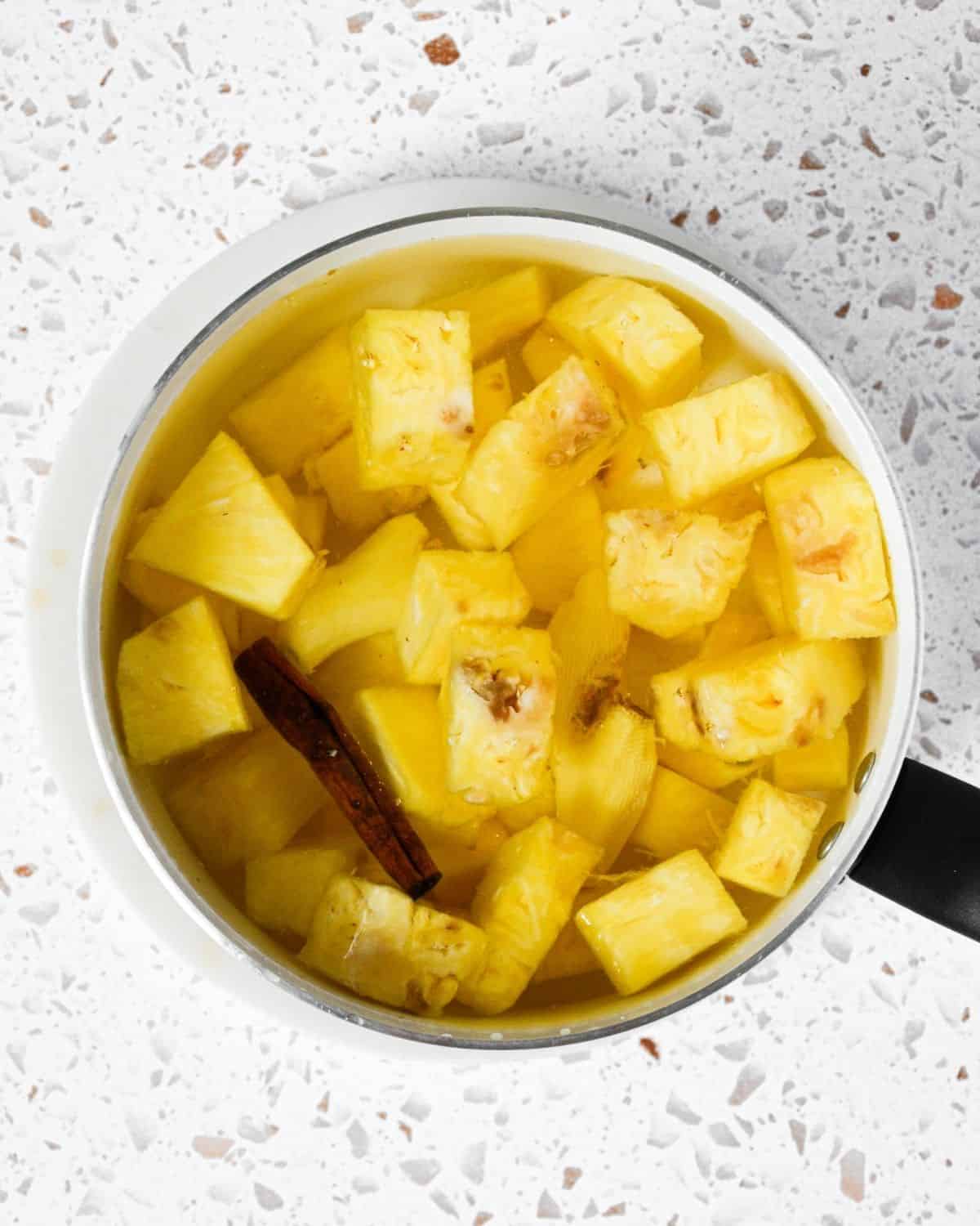 Pineapple and cinnamon sticks in a pot.