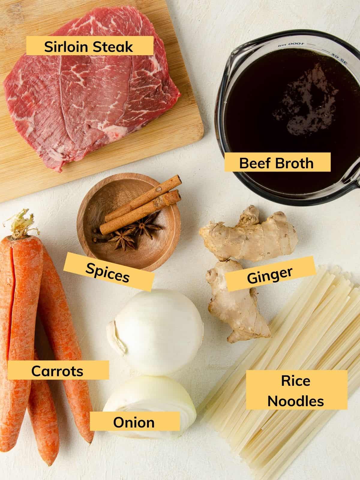 Ingredients to make your own gluten free pho: beef broth, spices, ginger root, rice noodles, onion, carrots and sirloin steak.