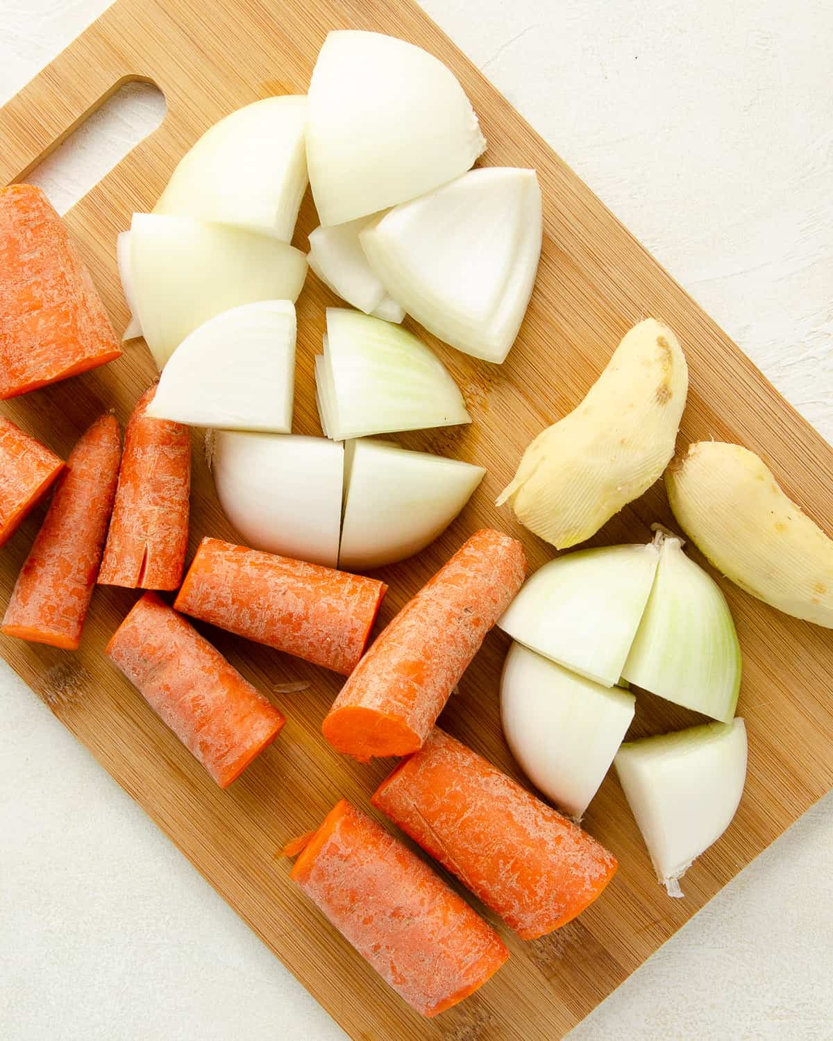 Chop the carrot, onion and ginger root into even cubes for adding flavor to the broth.