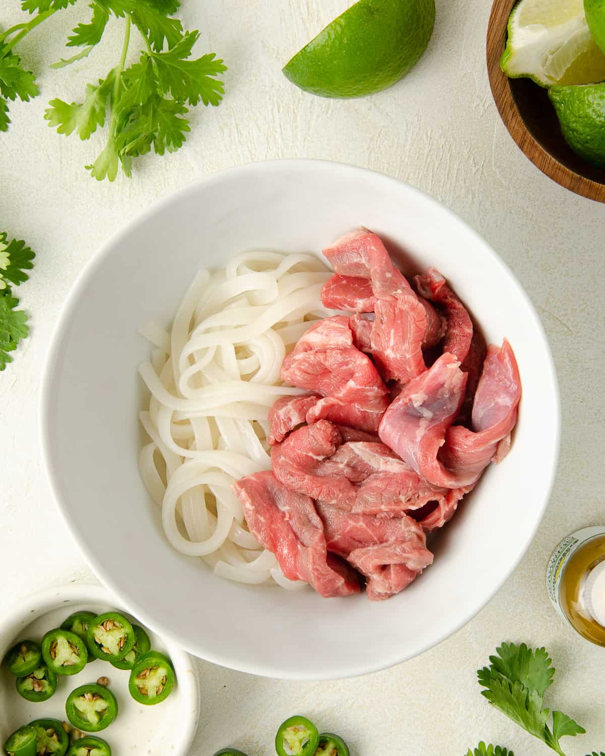 Place steak on top of the rice noodles to get ready to cook the steak.