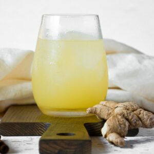 A close up of pineapple ginger juice in a small glass.