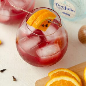 Close up view of a skinny cranberry margarita garnished with oranges.