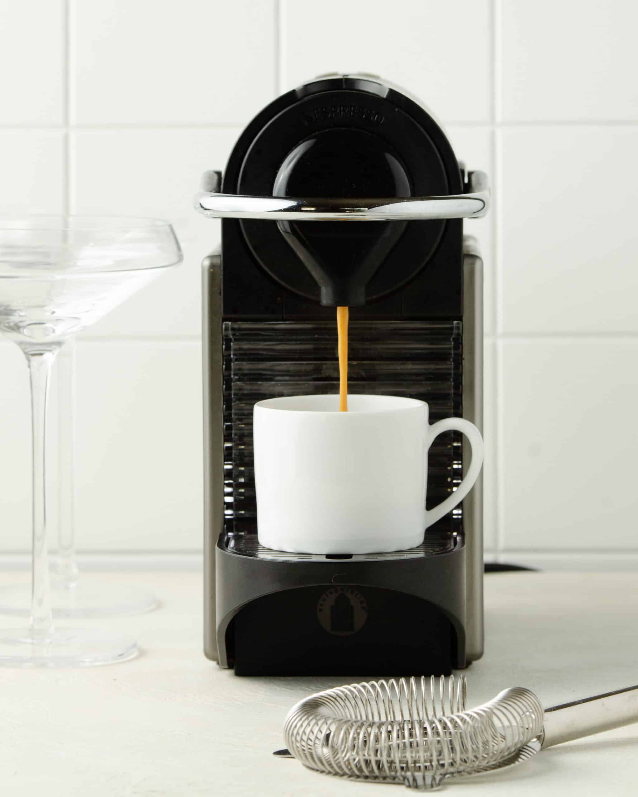 Brewing espresso into a white mug.