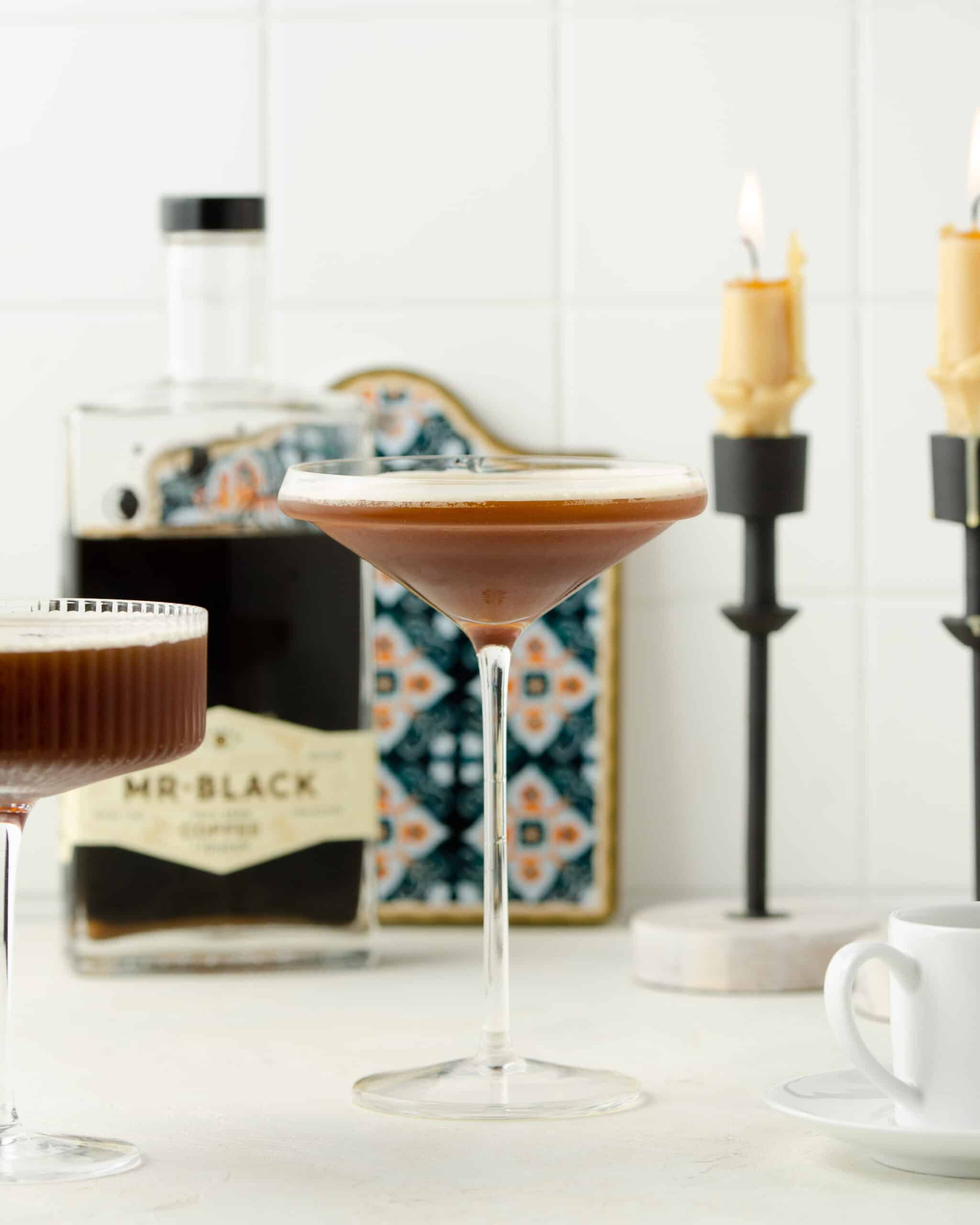 Espresso martini in a cocktail glass on a white countertop.