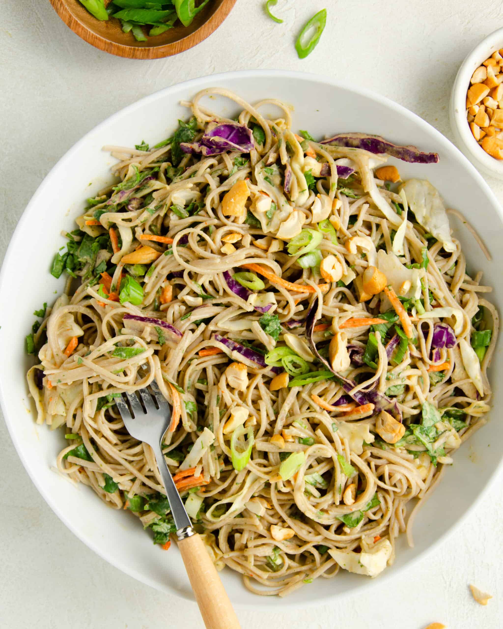 white bowl of cold soba noodle salad with spicy cashew dressing