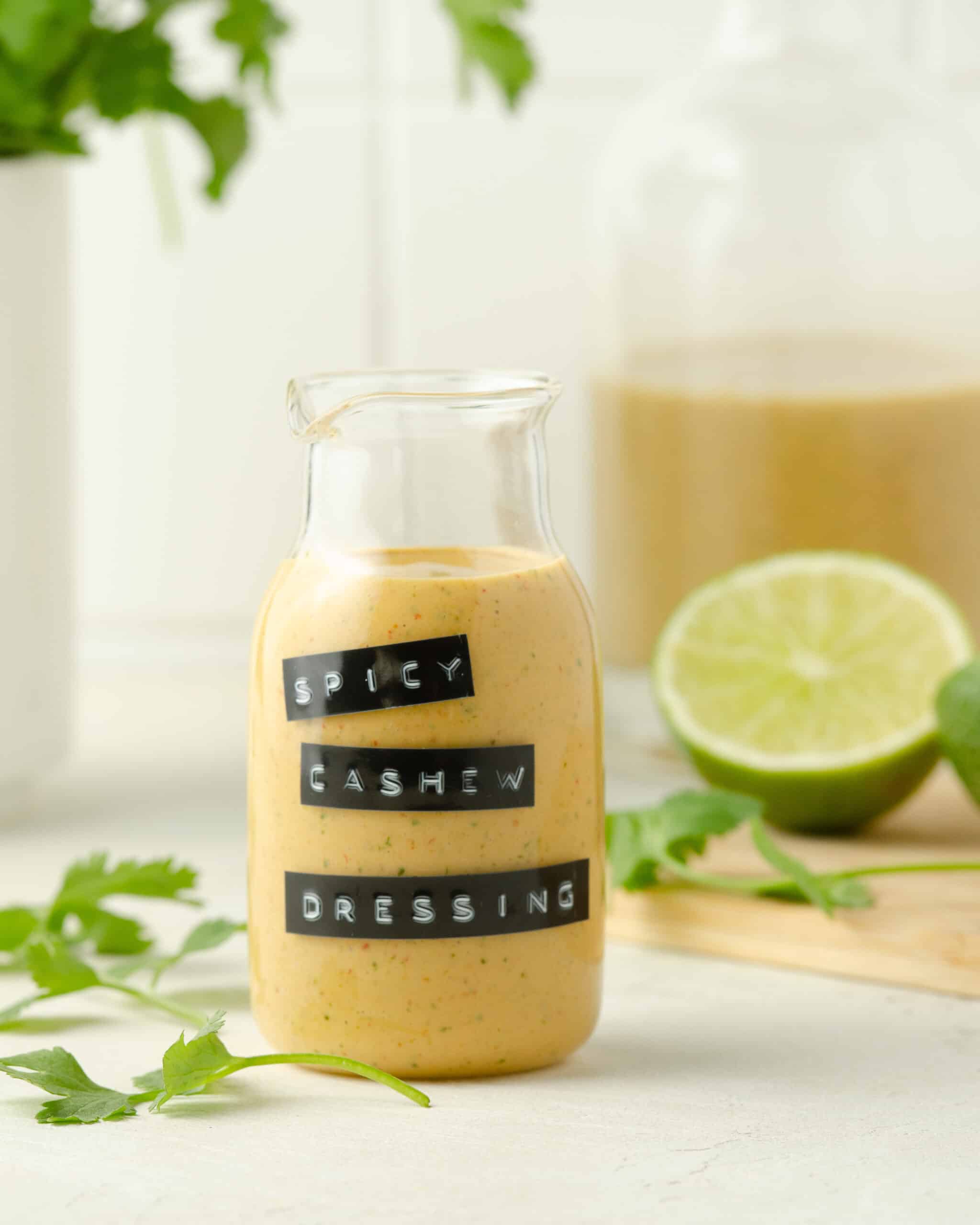 a jar of spicy cashew dressing on a white countertop 