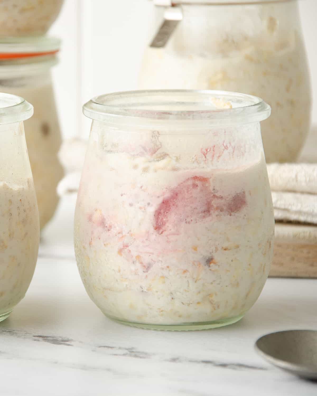 A jar of overnight protein oats with strawberry slices. 