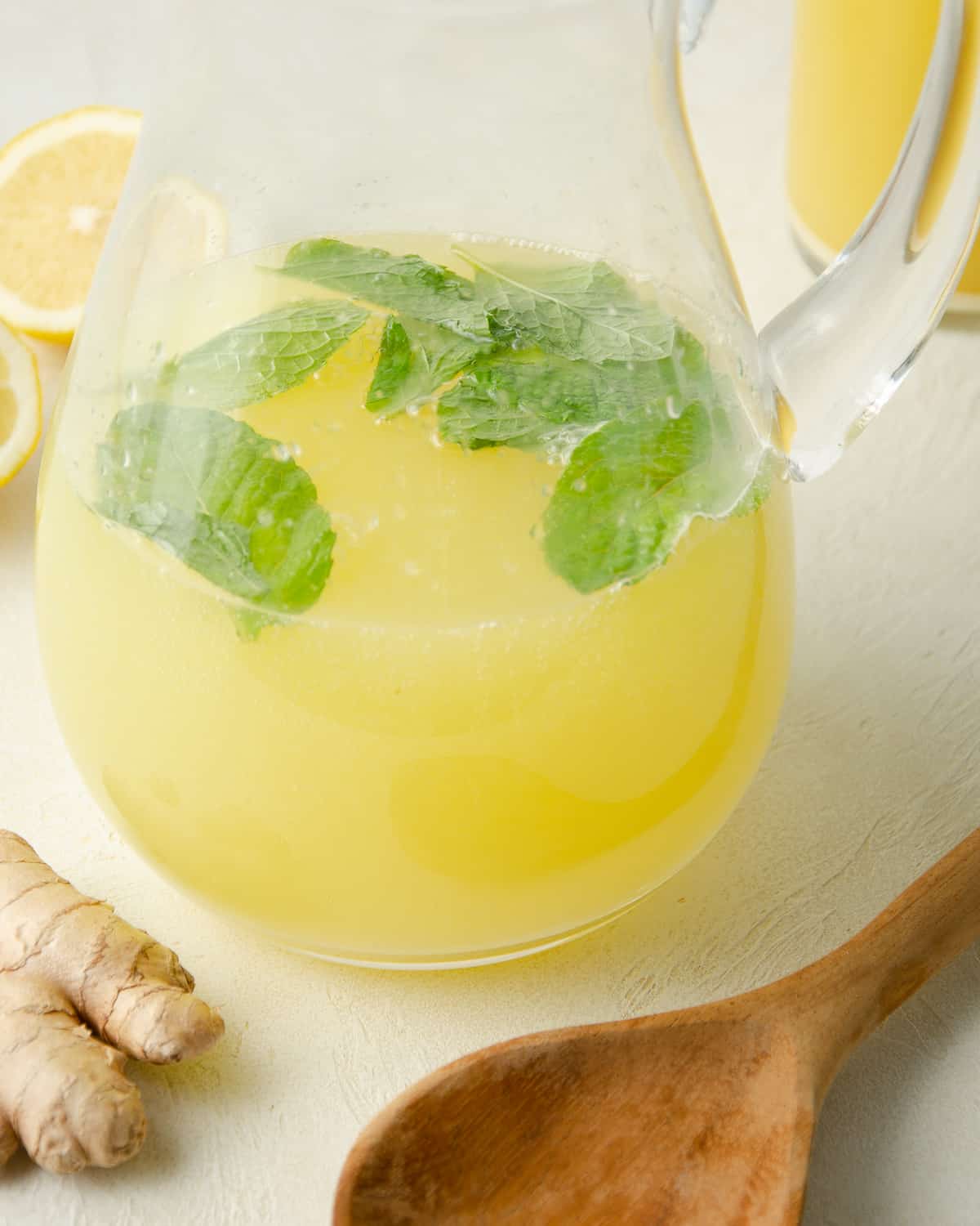 Fresh mint leaves in ginger lemonade a glass pitcher.