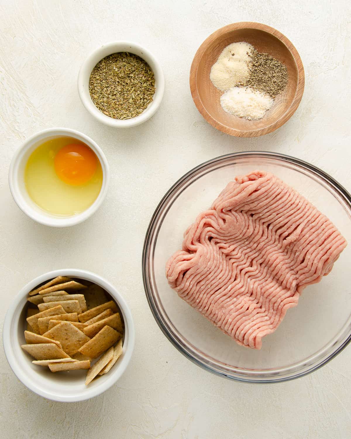 Ingredients needed to make gluten free meatballs: ground turkey, egg, gluten free crackers, and seasonings.