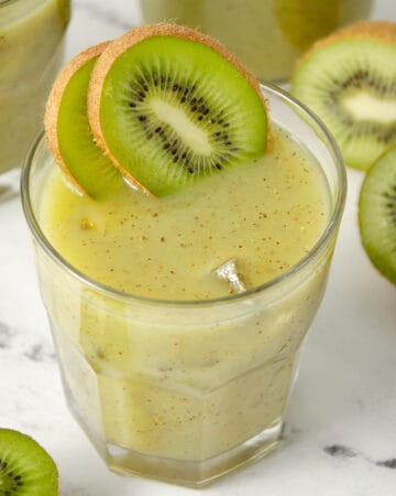 A glass of fresh kiwi juice with kiwi slices.