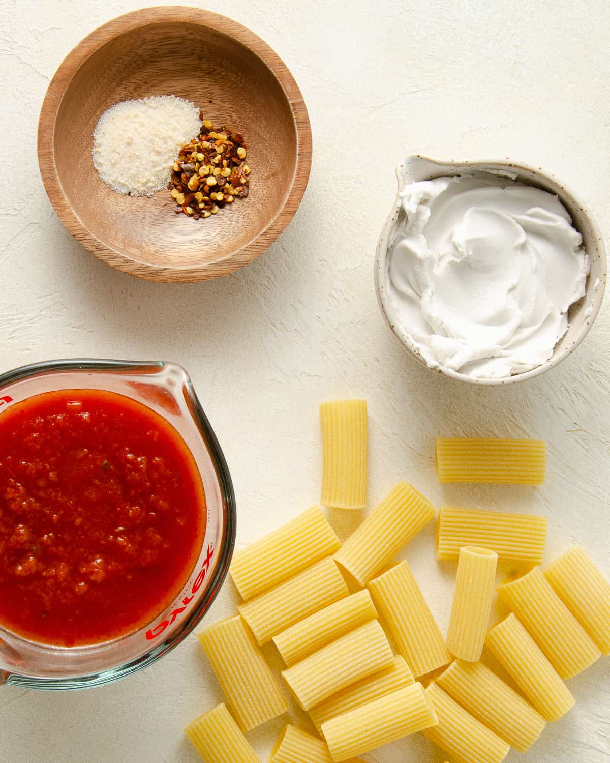 Ingredients needed for dairy free pink pasta sauce: garlic salt, red pepper flakes, marinara sauce, coconut cream, and pasta.