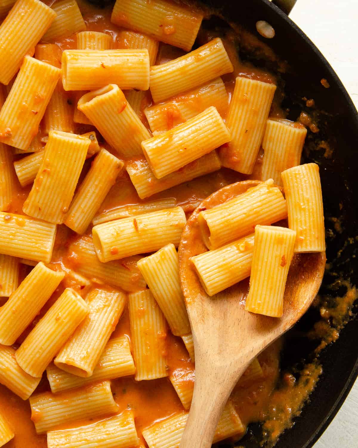 Skillet full of rigatoni and dairy free pink pasta sauce.