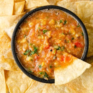 A featured image of a mango habanero salsa in a molcajete surrounded by tortilla chips.