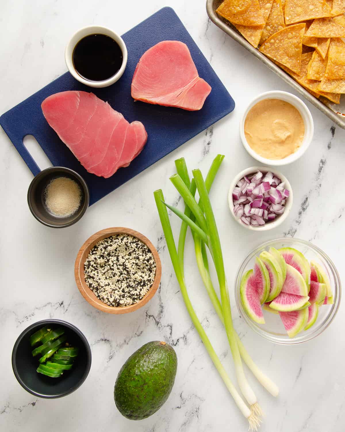 Ingredients for ahi tuna nachos on a white countertop.