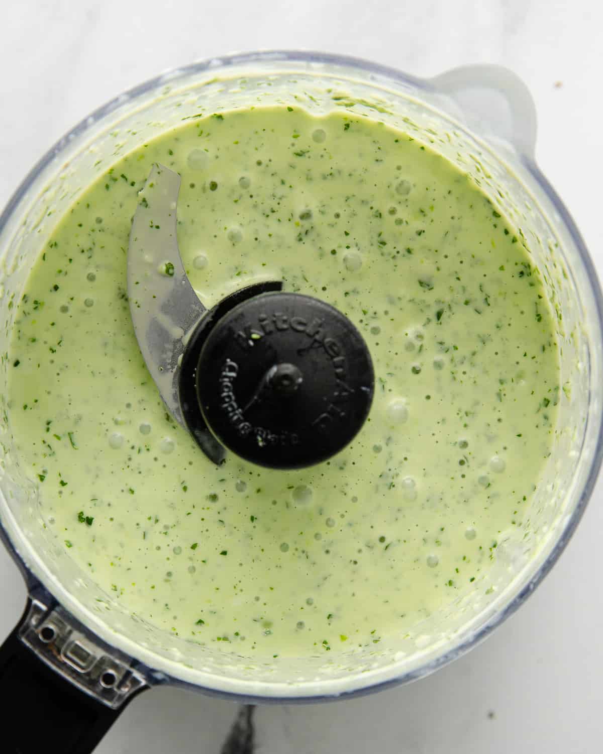 Blended cilantro garlic sauce in a food processor.