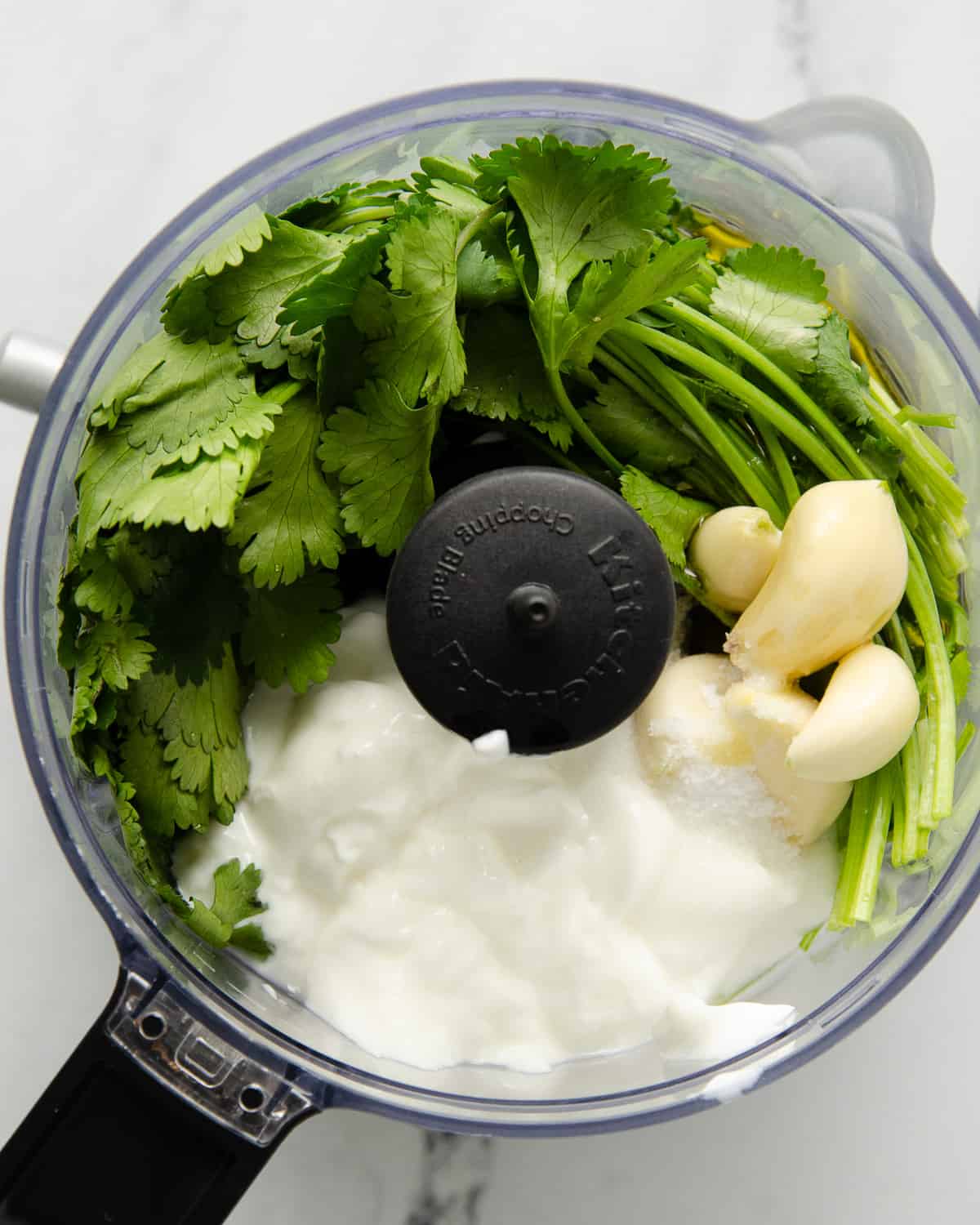 Ingredients for cilantro garlic sauce in a food processor before blending.