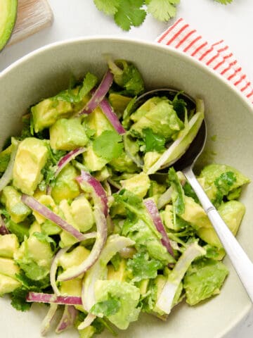 Featured image of a Mexican avocado salad in a large green bowl.