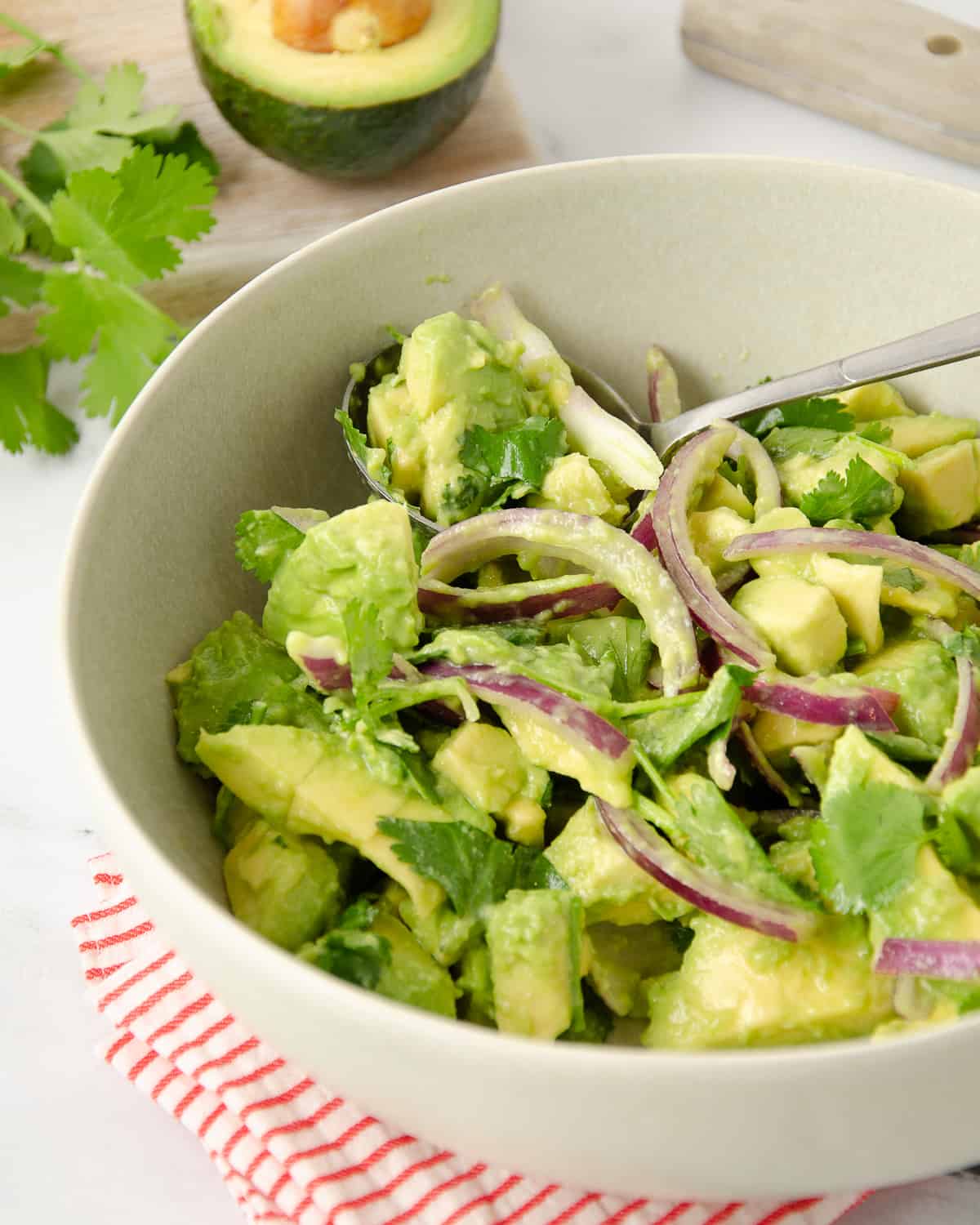 A close up view of an avocado salad in a large bowl.