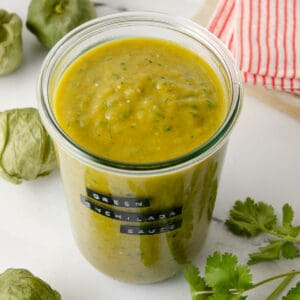 Featured image of a large jar of green enchilada sauce on a marble counter.
