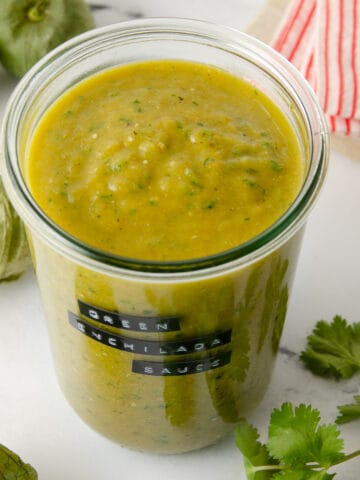 Featured image of a large jar of green enchilada sauce on a marble counter.