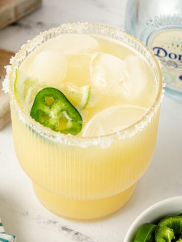 A featured image of a spicy skinny margarita garnished with a fresh lime wedge and jalapeno slice.