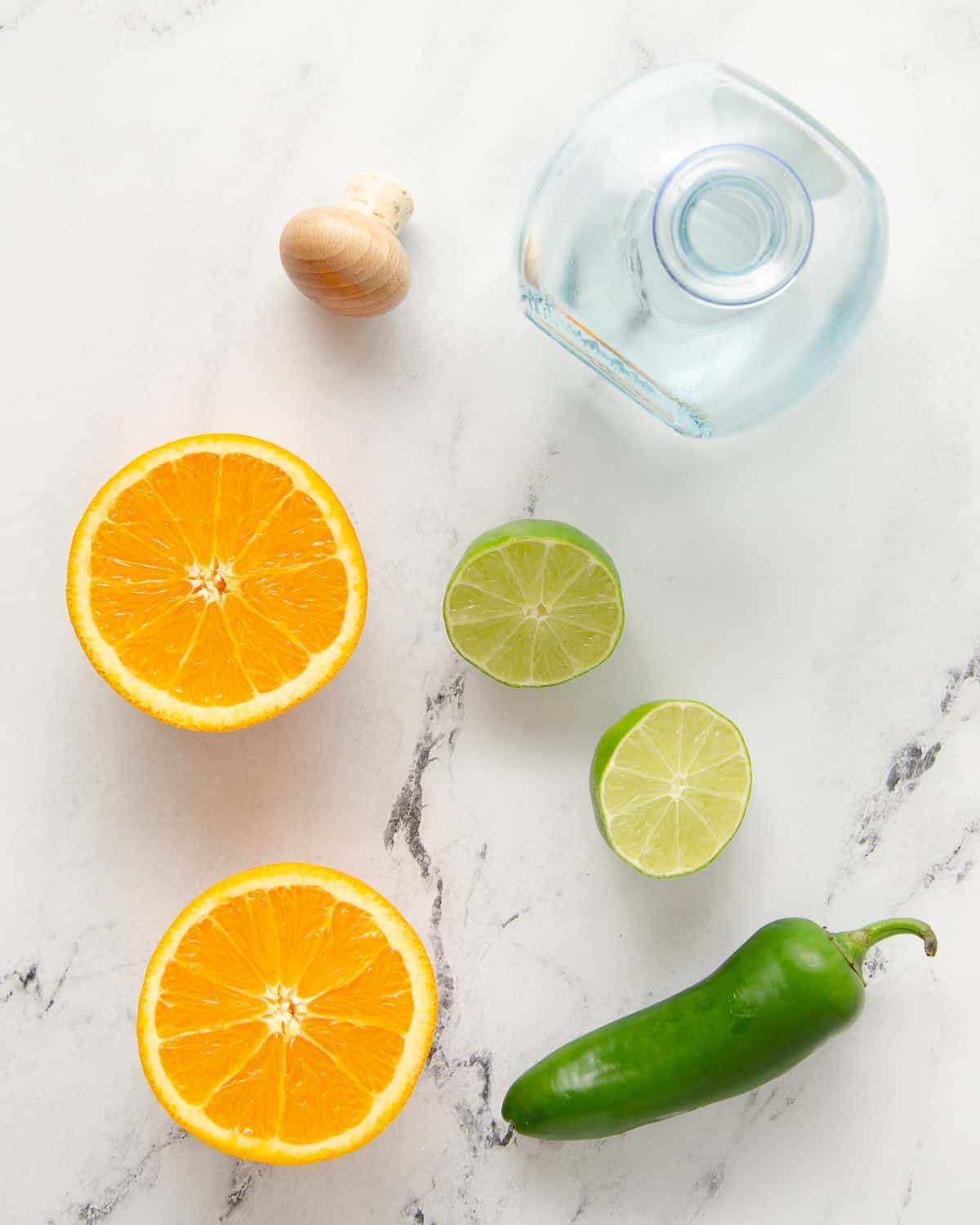 Ingredients to make a spicy margarita: jalapeno, orange, lime and tequila.