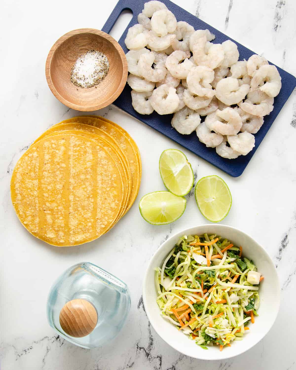 Ingredients needed for tequila lime shrimp tacos: shrimp, seasonings, slaw, lime, and tequila.