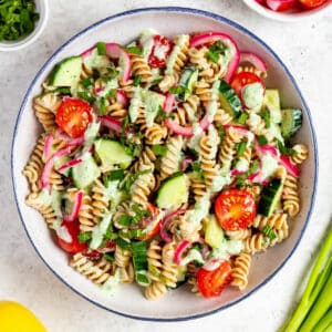 Protein Pasta Salad in a serving bowl topped with creamy lemon mint dressing and fresh mint.