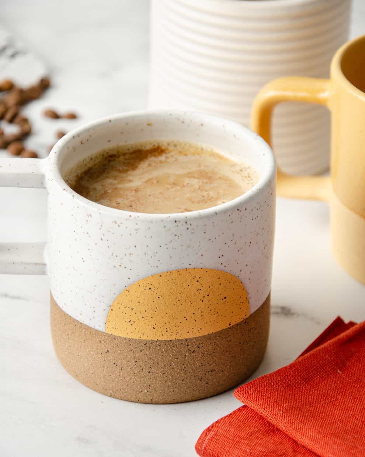 Spanish latte in a mug topped with a sprinkle of cinnamon.
