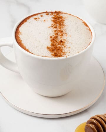 White coffee mug filled with a honey cinnamon latte.