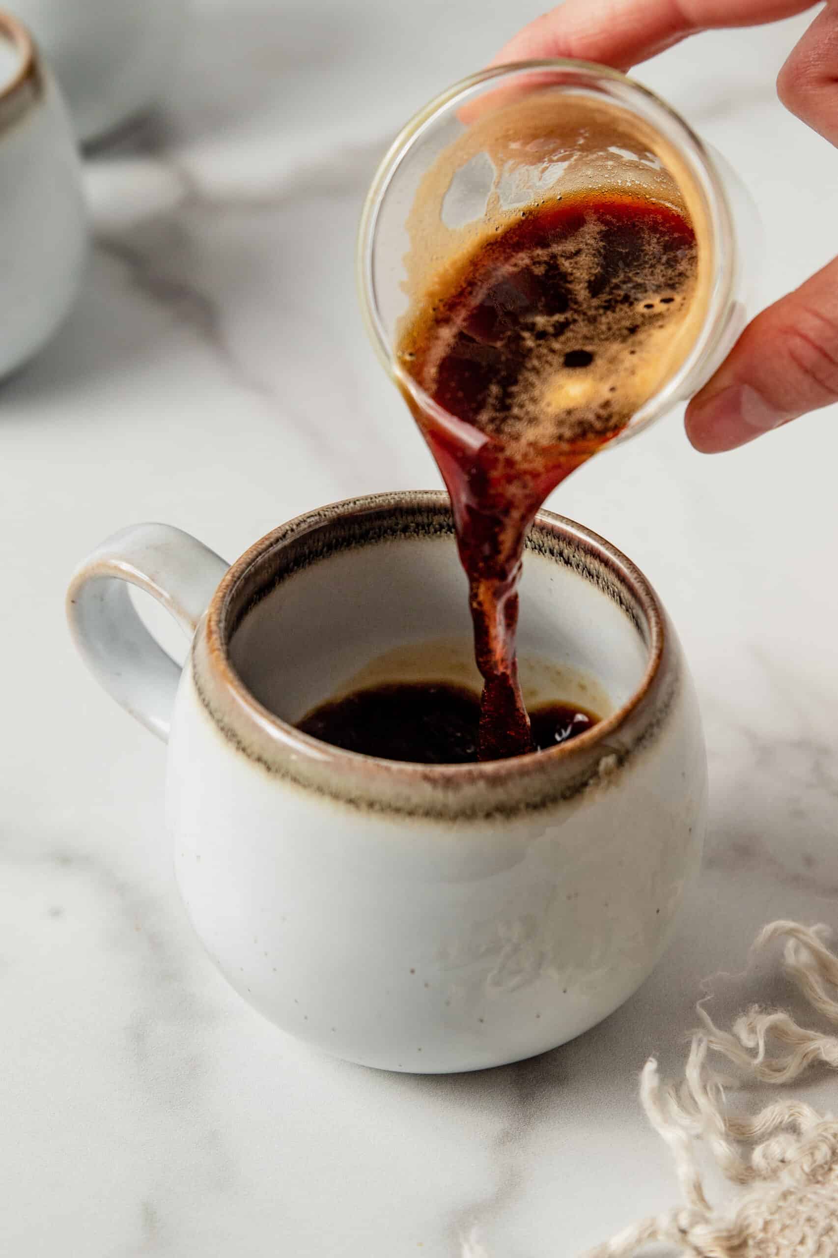 Pouring espresso into a latte mug.